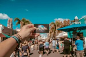 Mão segurando ingresso de parques da Universal, em Orlando